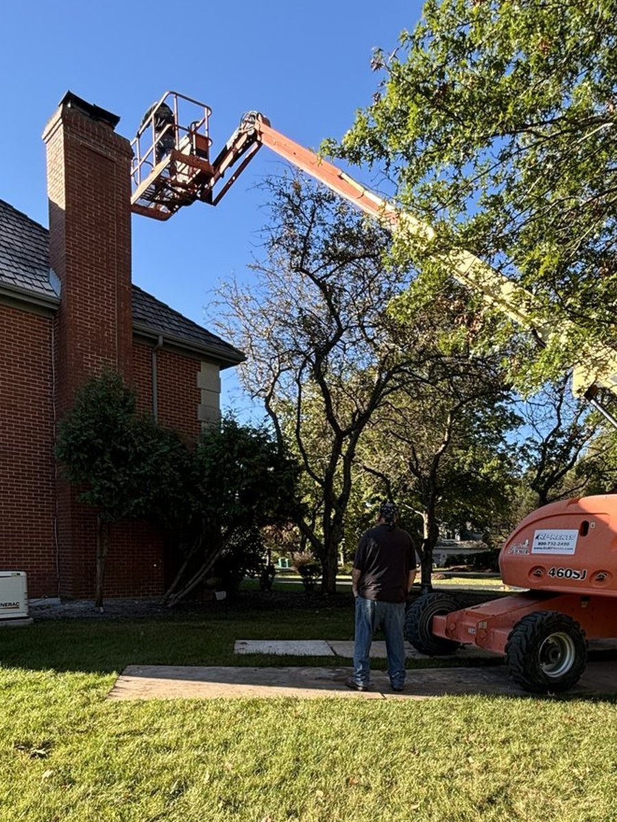Boom lift positioned at a chimney for masonry repair