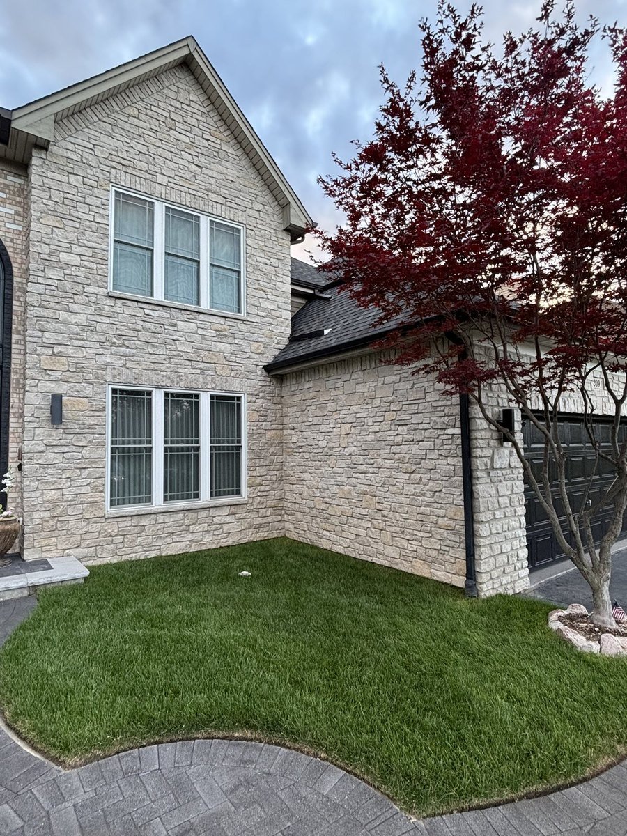 Cultured stone masonry with finished landscaping