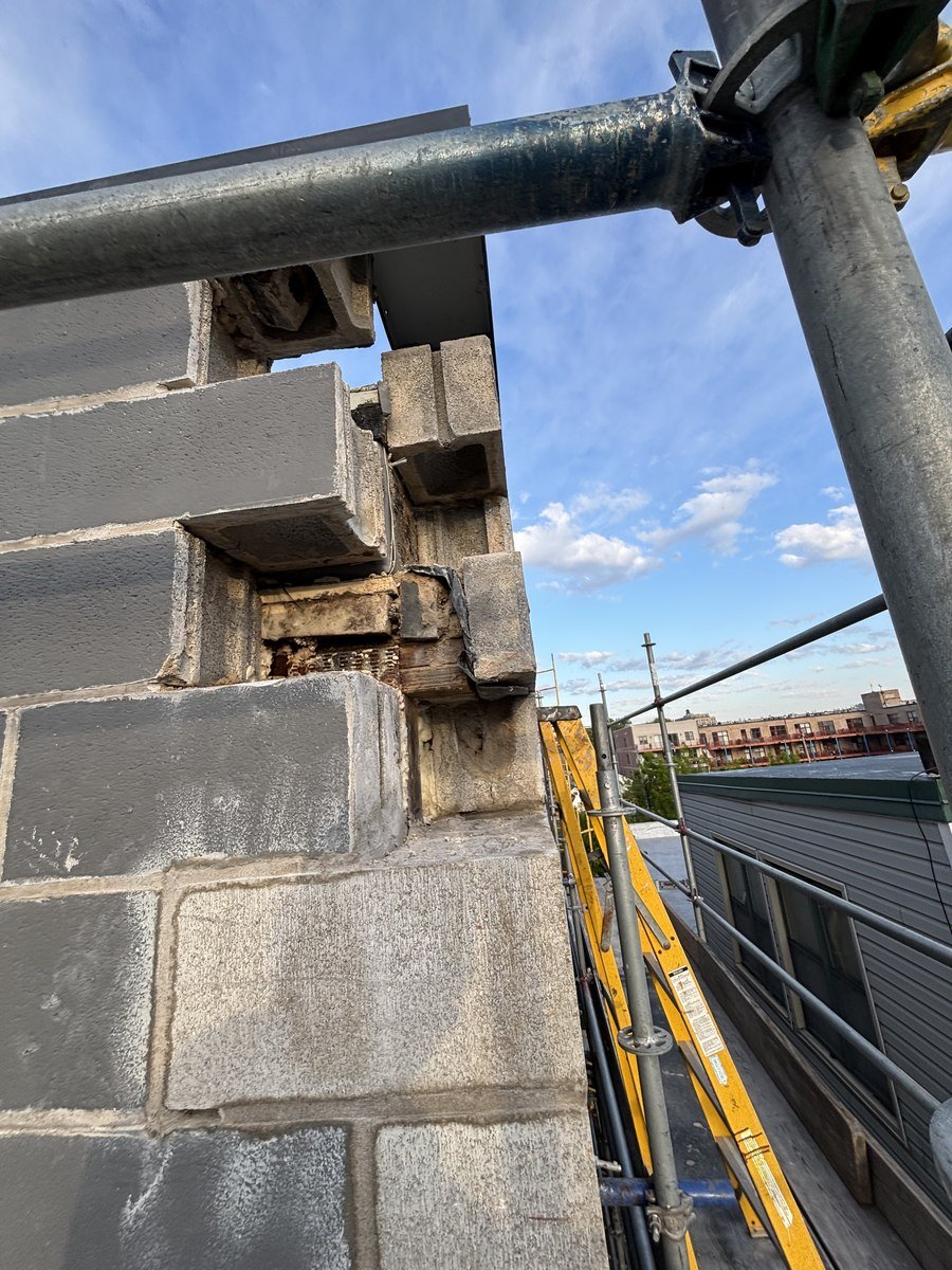 Deteriorated block wall with exposed framing before repair